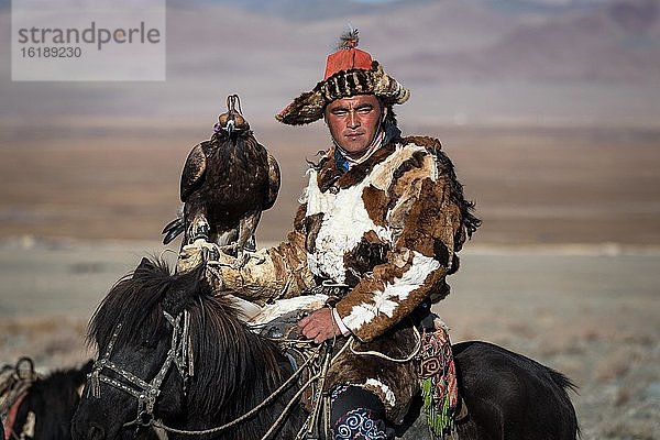 Mongolischer Reiter bei der traditionellen Jagd mit Adler  Provinz Bayan-Ulgii  Mongolei  Asien