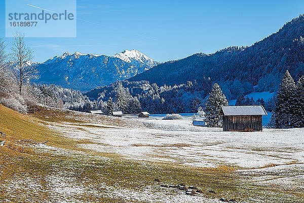 Berglandschaft im Winter  vorne Holzhütten  hinten Karwendelgebirge  Bayerisches Oberland  Garmisch-Patenkirchen  Bayern  Deutschland  Europa