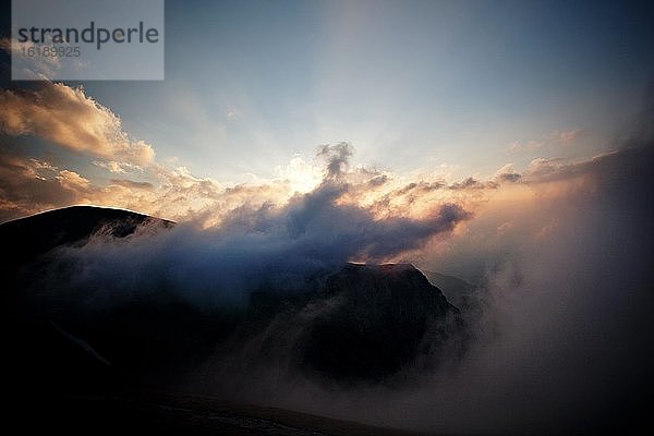 Sonnenuntergang über einem Gebirgszug  der die Wolken durchschneidet  Czerwone Wierchy  Tatra-Gebirge  Tatra-Nationalpark  Polen  Europa