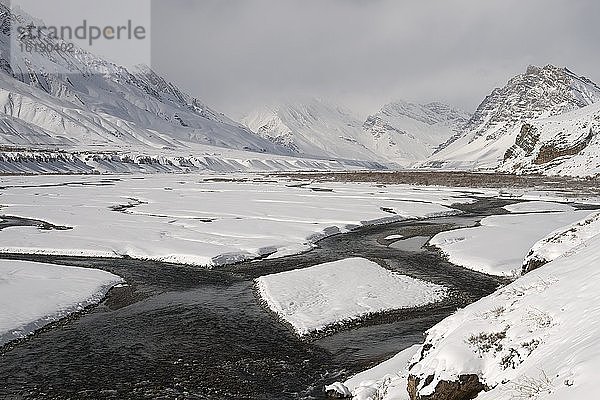 Fluss fließt durch schneebedeckte Berge in Spiti  einem hochgelegenen gefrorenen Plateau  der Heimat der Schneeleoparden im indischen Himalaja  Indien  Asien
