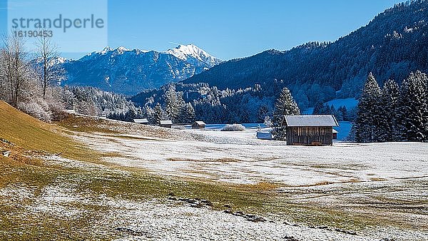 Berglandschaft im Winter  vorne Holzhütten  hinten Karwendelgebirge  Bayerisches Oberland  Garmisch-Patenkirchen  Bayern  Deutschland  Europa