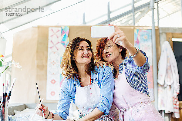 Zwei Frauen im Kreativstudio  beim Selfie  mit Smartphone