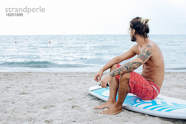 Surfer mit Surfbrett am Meer