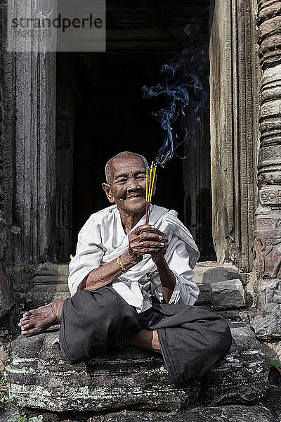 Devotee-Nonne  die Weihrauch anzündet und Gebete im Preah-Khan-Tempel  Angkor  Kambodscha  darbringt