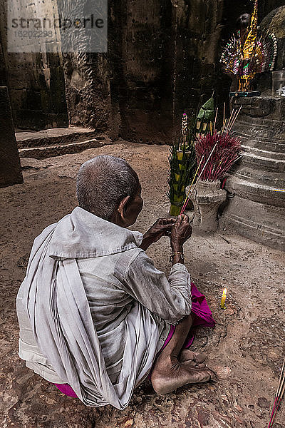 Devotee-Nonne  die Weihrauch anzündet und Gebete im Preah-Khan-Tempel  Angkor  Kambodscha  darbringt