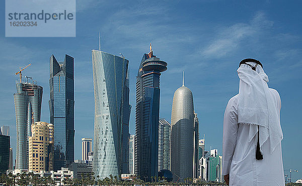 Mann mit Blick auf futuristische Wolkenkratzer in der Innenstadt von Doha  Katar
