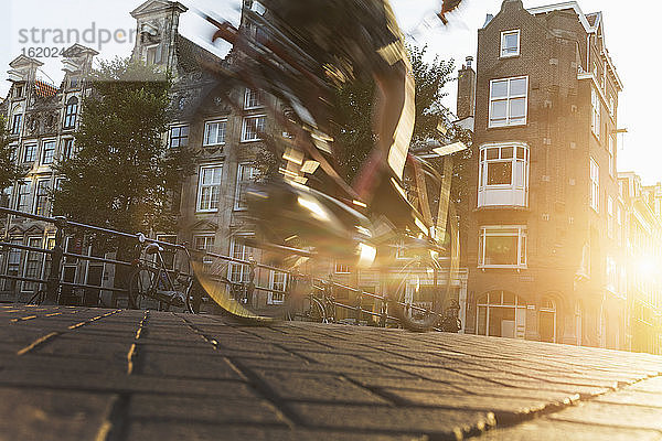 Nahaufnahme eines Radfahrers auf einer gepflasterten Straße  Amsterdam  Niederlande