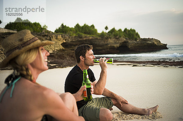 Pärchen sitzt am Strand und trinkt Bier  Nusa Lembongan  Indonesien
