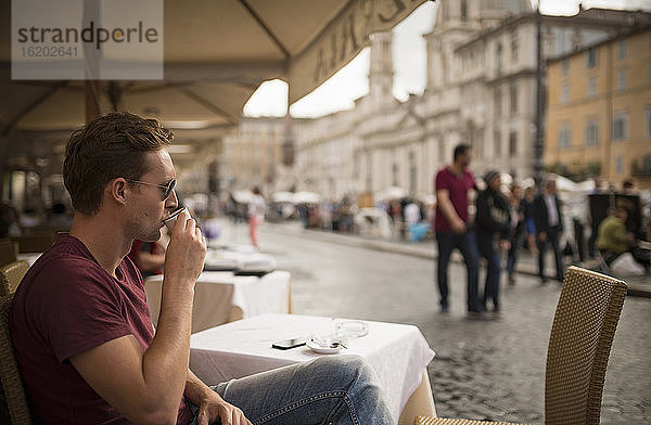 Mann genießt Espresso im Restaurant  Piazza Navona  Rom  Italien
