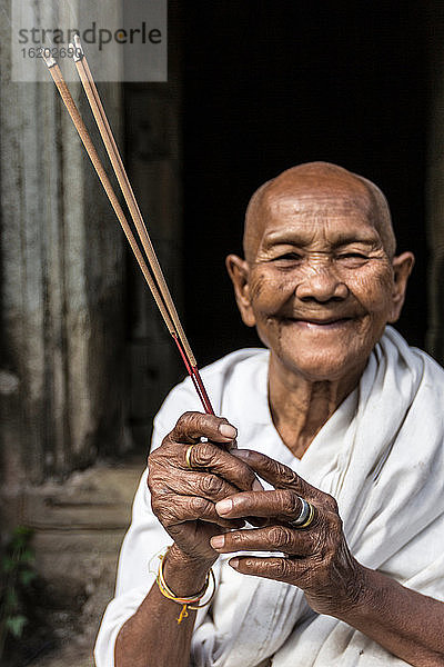 Devotee-Nonne  die Weihrauch anzündet und Gebete im Preah-Khan-Tempel  Angkor  Kambodscha  darbringt