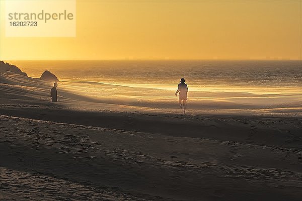 Pärchen am Strand von Golden Bay bei Sonnenuntergang  Südinsel  Neuseeland