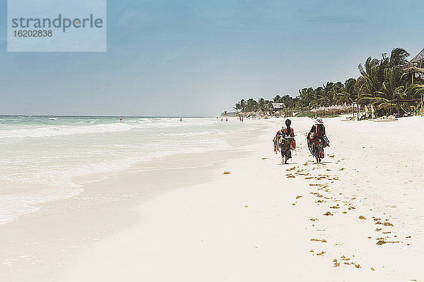 Zwei Einheimische gehen am Strand entlang  Tulum  Mexiko