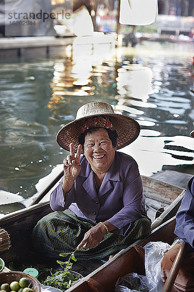 Porträt einer glücklichen älteren Marktstandbesitzerin  Damnoen Saduak Floating Market  Thailand