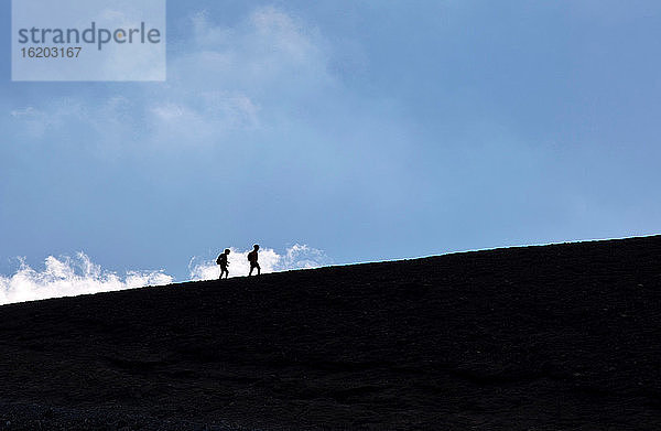 Silhouette von Wanderern auf staubiger Piste