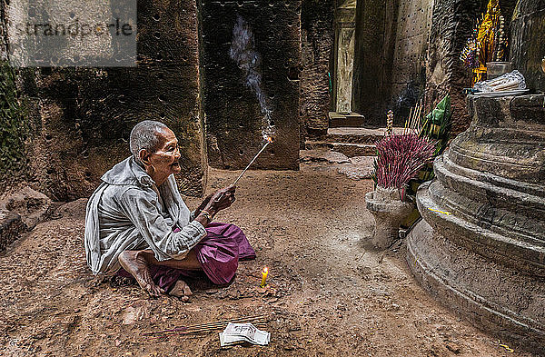 Devotee-Nonne  die Weihrauch anzündet und Gebete im Preah-Khan-Tempel  Angkor  Kambodscha  darbringt