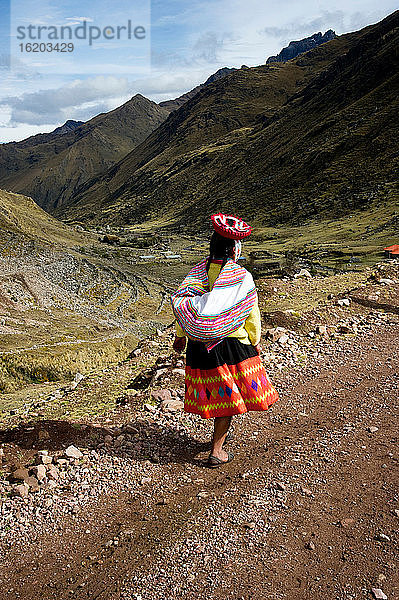 Mädchen geht auf einem Pfad mit Blick auf Qelqanqa  Peru