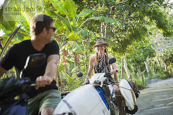 Pärchen auf Motorrädern mit Surfbrettern  Nusa Lembongan  Indonesien