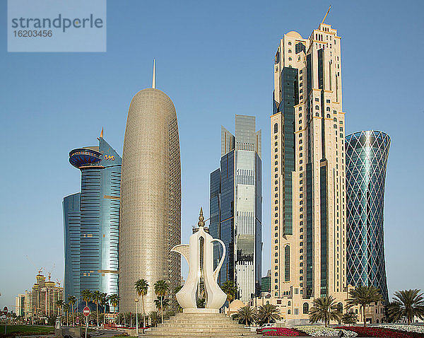 Futuristische Wolkenkratzer und eine riesige Kaffeekannen-Skulptur (Dallah) in der Innenstadt von Doha  Katar