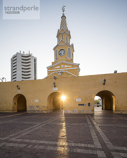 Uhrturm und Stadttor in der Altstadt  tiefstehende Sonne auf einem gepflasterten Platz.