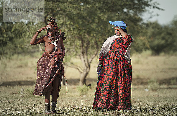 Zwei Himba-Frauen  die ihre Augen vor der Sonne schützen  Namibia  Afrika