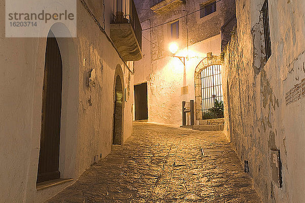 Gepflasterte Dorfgasse in der Abenddämmerung