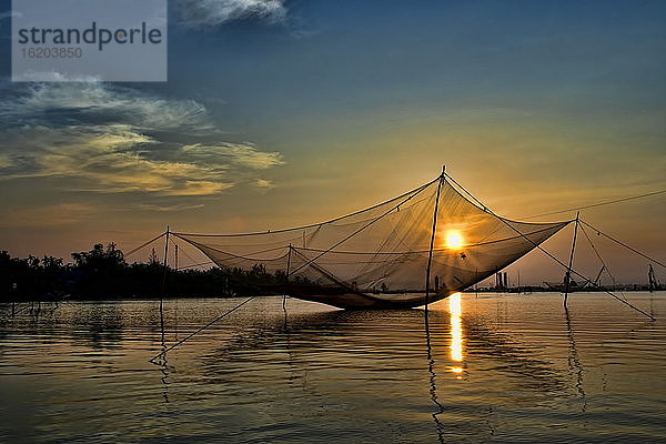 Gestilltes Fischernetz über dem Fluss bei Sonnenuntergang  Hoi An  Vietnam