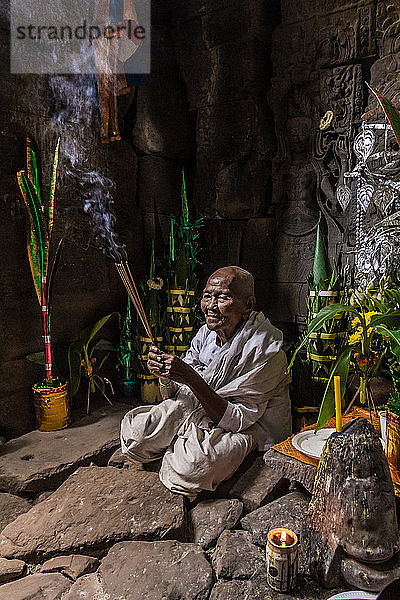 Devotee-Nonne  die Weihrauch anzündet und Gebete im Preah-Khan-Tempel  Angkor  Kambodscha  darbringt