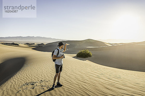 Mann mit Fernglas  Mesquite Flat Sand Dunes  Death Valley National Park  Furnace Creek  Kalifornien  USA