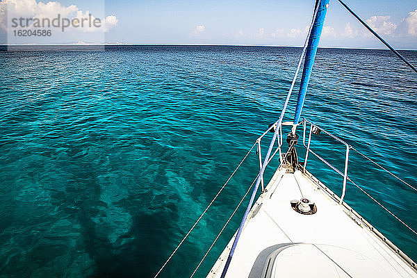 Der Bug einer Yacht schneidet durch das kristallklare türkisfarbene Wasser des Mittelmeers  Griechenland