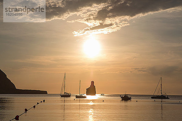 Silhouettierte Yachten bei Sonnenuntergang am Strand von Benirras  Ibiza  Spanien