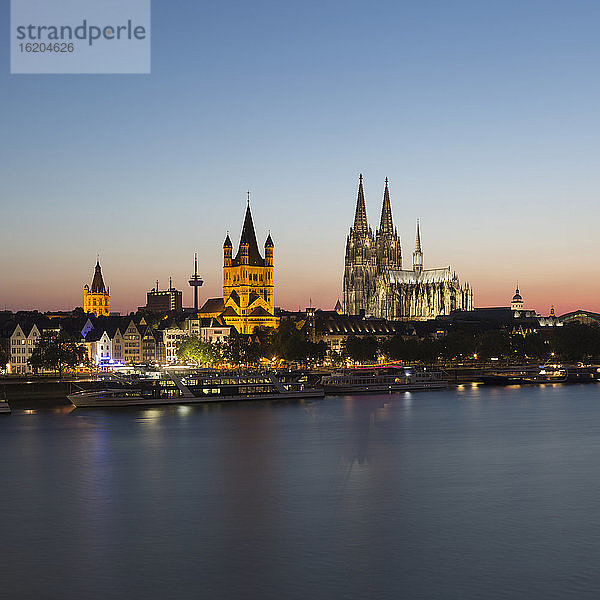 Stadtbild am Wasser mit Rathaus  Großer Martinskirche und Kölner Dom in der Abenddämmerung  Köln  Deutschland