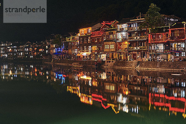 Traditionelle Gebäude am Flussufer  bei Nacht beleuchtet  Fenghuang  Hunan  China