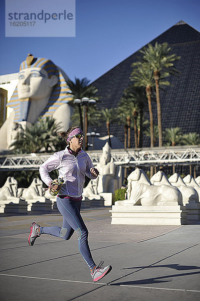 Mittlere erwachsene Läuferin  die vor dem Pyramid Hotel am Las Vegas Strip läuft  Las Vegas  Nevada  USA