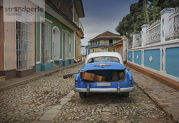 Altes amerikanisches Auto mit Kontrabass im Kofferraum in einer Kolonialstraße  Trinidad  Sancti Spiritus  Kuba