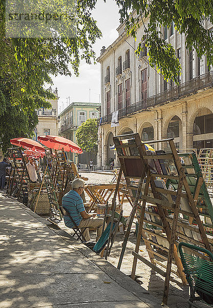 Inhaber eines Flohmarktstandes auf der Plaza de Armas  Havanna  Kuba