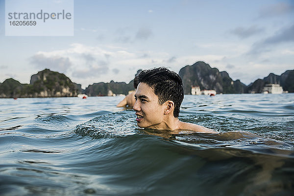 Mann schwimmt in den Gewässern der Ha Long Bay  Vietnam
