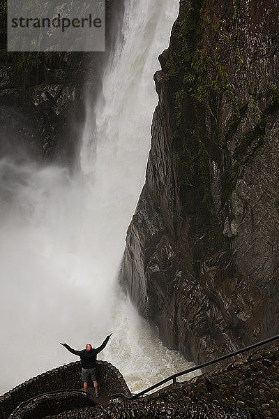 Hochformatige Ansicht eines männlichen Touristen am Wasserfall Pailon del Diablo  Ecuador