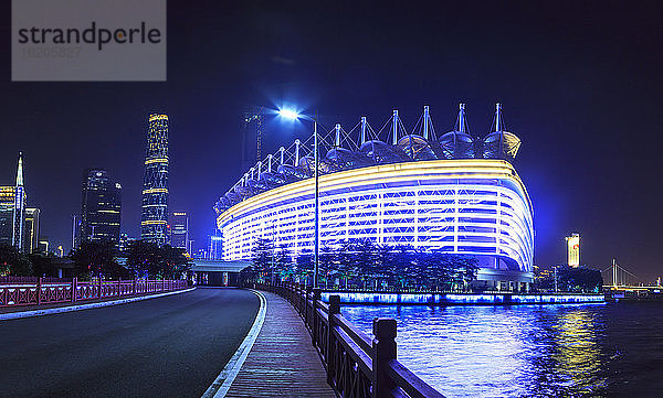 Beleuchtetes Olympiastadion am Flussufer bei Nacht  Guangzhou  China