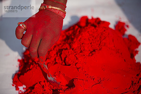 Nahaufnahme einer Hand  die rotes Pulver mischt  Jaipur  Rajasthan  Indien