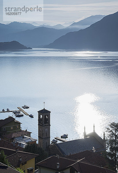 Dorf am Wasser und ferne Berge bei Sonnenaufgang  Comer See  Italien