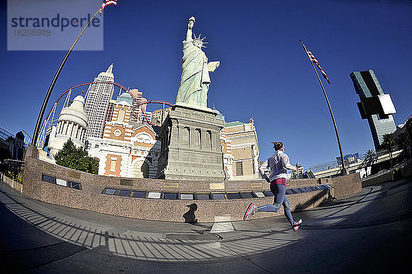 Mittlere erwachsene Läuferin läuft vor der Freiheitsstatue auf dem Las Vegas Strip  Las Vegas  Nevada  USA