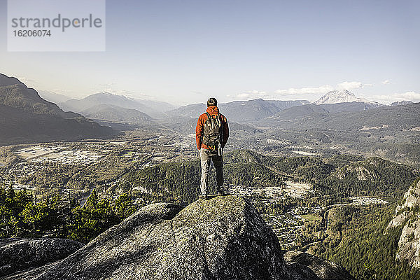 Mann steht auf einem Berg und betrachtet die Aussicht  Stawamus Chief  mit Blick auf die Howe Sound Bay  Squamish  British Columbia  Kanada