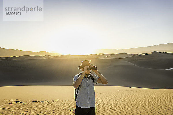 Mann mit Fernglas  Mesquite Flat Sand Dunes  Death Valley National Park  Furnace Creek  Kalifornien  USA