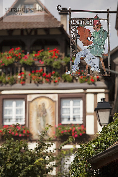 Geschäftsschilder und mittelalterliches Haus im Hintergrund  Kaysersberg  Elsass  Frankreich