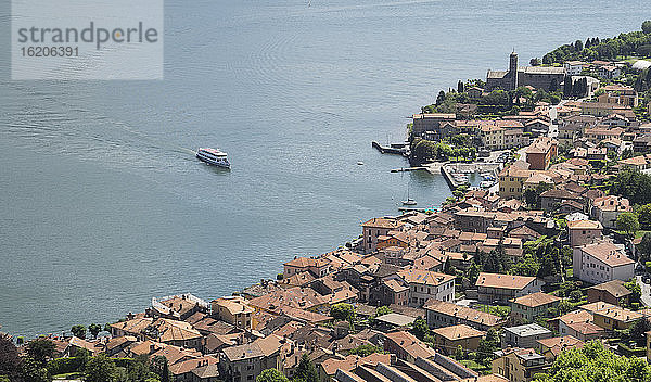 Blick von oben auf eine Fähre  die sich einem Dorf am Wasser nähert  Comer See  Italien