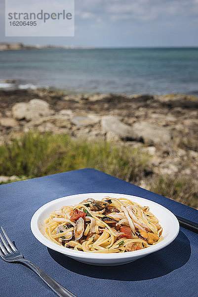 Schüssel mit Meeresfrüchte-Pasta auf einem Restauranttisch an der Küste  Apulien  Italien