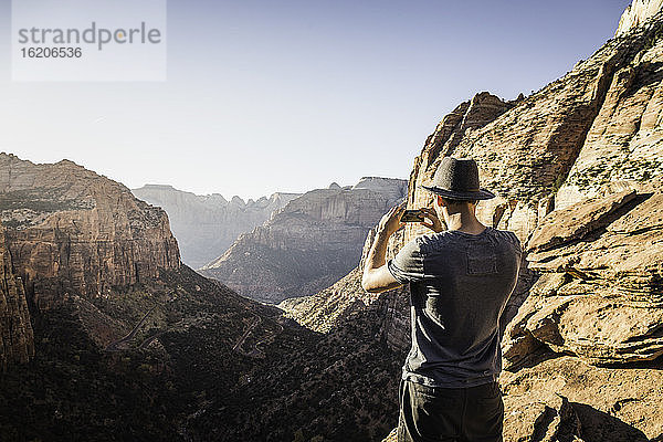 Mann stehend auf Berg  fotografierend  Blick Zion National Park  Utah  USA