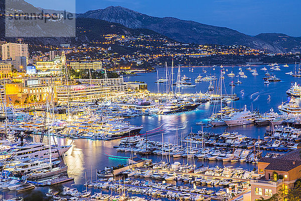 Blick von oben auf die Superyachten der Monaco Yacht Show in der Abenddämmerung
