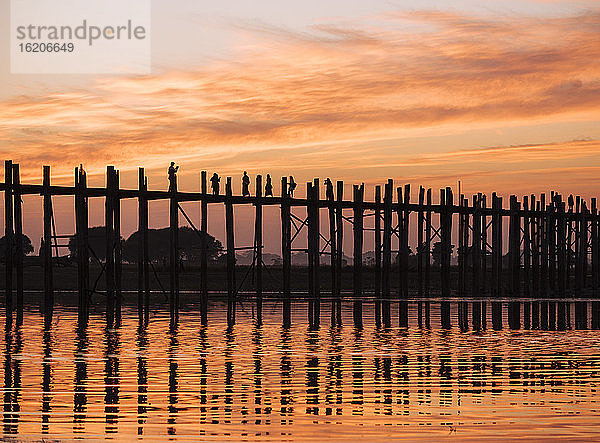 Silhouette von Menschen auf der U Bein-Brücke bei Sonnenuntergang  Mandalay  Mandalay-Region  Myanmar