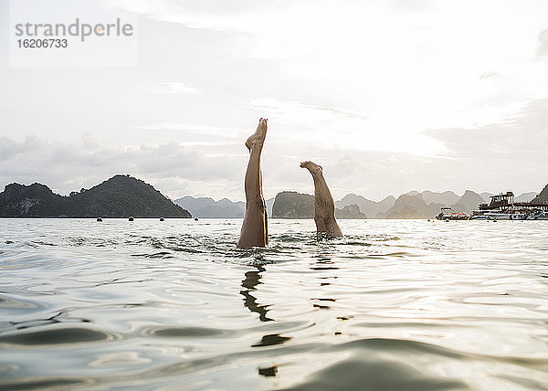 Paar macht Handstand im Wasser der Ha Long Bay  Vietnam